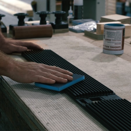 Hands holding Ruark R5 MiE’s wood grille